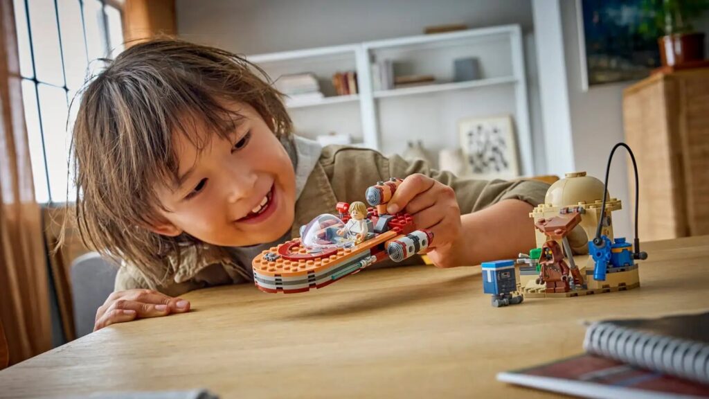 A child playing with the interactive LEGO Star Wars Millennium Falcon set